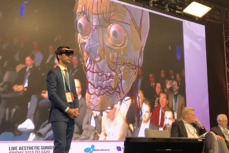 Dr. Cotofana from Albany Medical College on stage taking the audience through a tour of the facial anatomy using BioDigital‘s interactive, 3D mixed reality solution on the HoloLens at IMCAS World Congress. title=